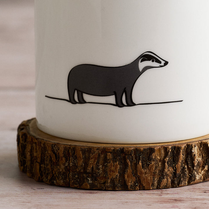 White mug with Badger on a wooden coaster