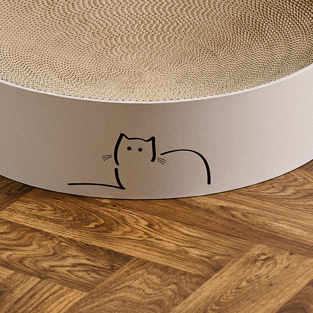 Close up of special edition CatLoaf round cat scratcher featuring Loafing Cat - placed on a wooden parquet floor.