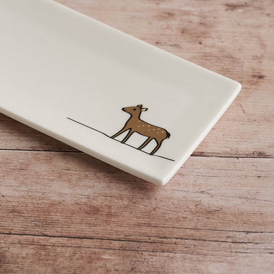 Rectangular white mini tray with a brown deer illustration on a wooden surface