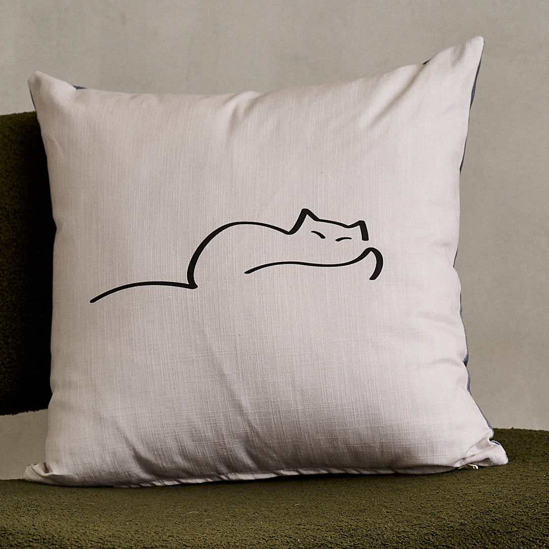 Dreaming Cat Cushion on green sofa chair