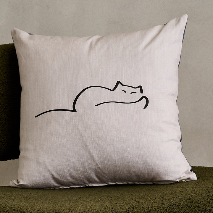 Dreaming Cat Cushion on green sofa chair