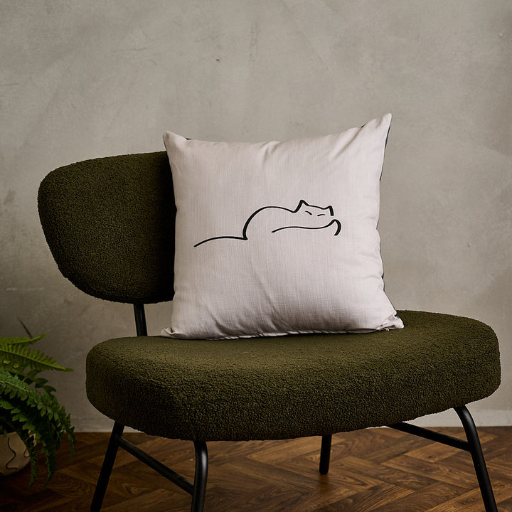 Dreaming Cat Cushion on green sofa chair