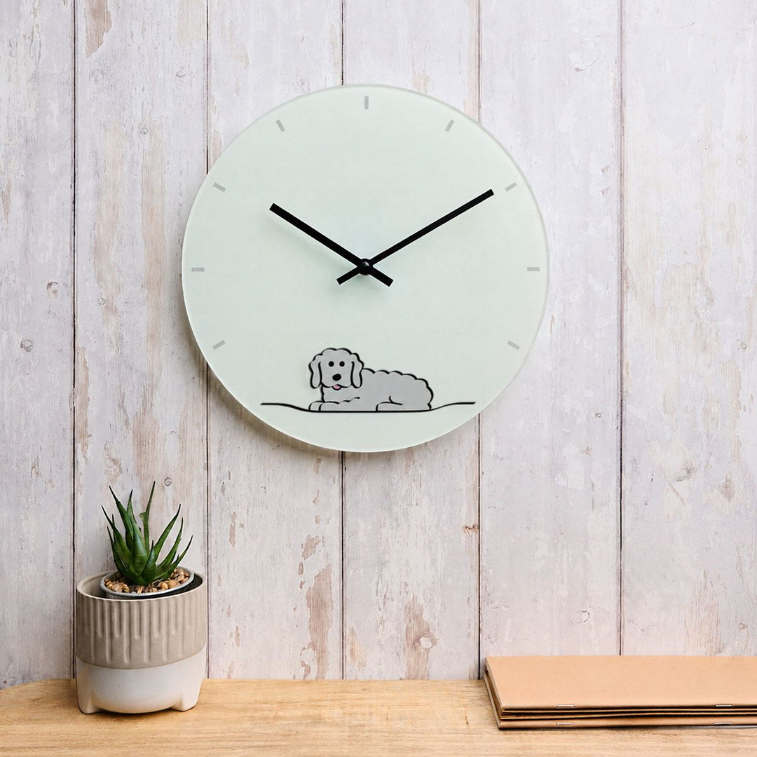 Fluffy Dog Glass Wall Clock 30cm on a white panelled wood wall with plant and books
