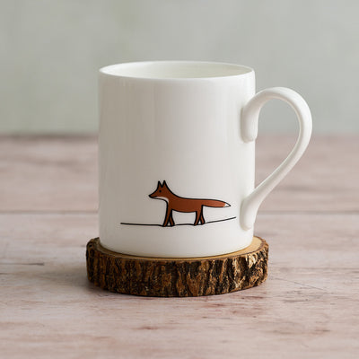 White mug with Fox illustration on a wooden coaster