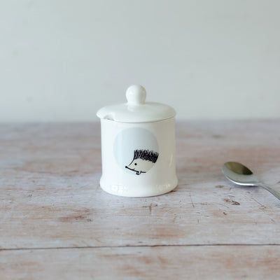 White fine bone china jam pot with a hedgehog design on a wooden surface