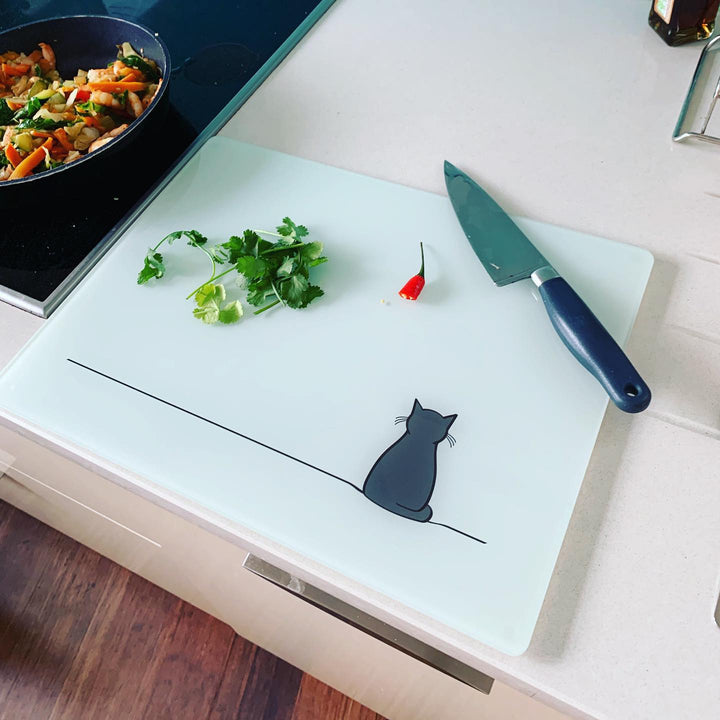 Sitting Cat Glass Worktop Saver with chopped herbs