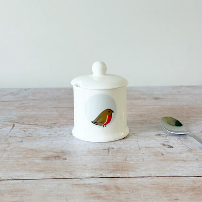 White fine bone china jam pot with a robin bird design on a wooden surface