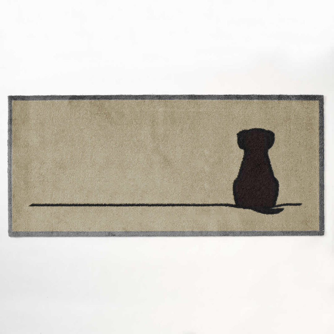 A rectangular beige doormat with a dark grey border, featuring a brown Sitting Dog on a thin horizontal line across the lower half.