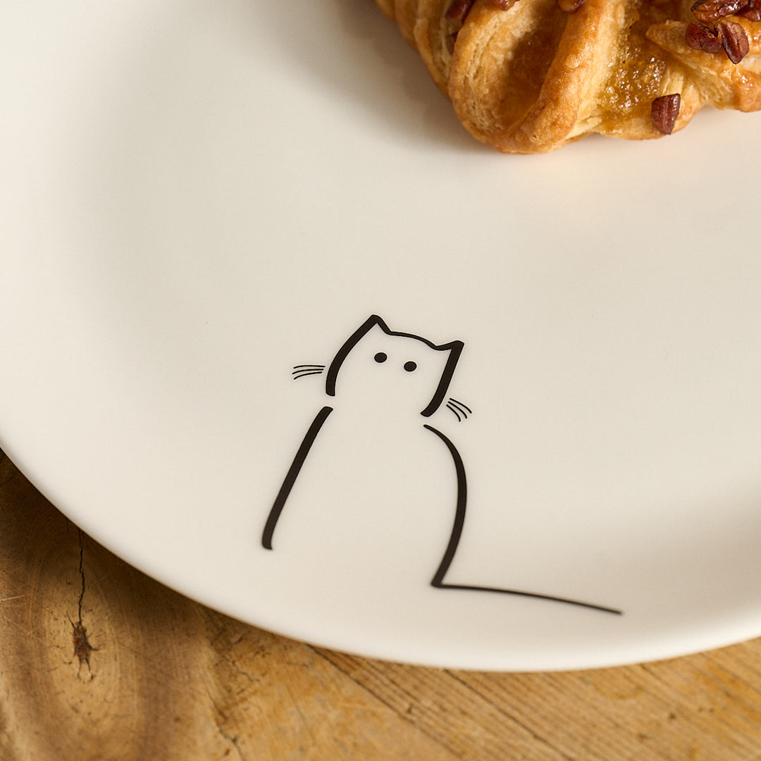 Waiting Cat Side Plate and a pastry on a wooden surface