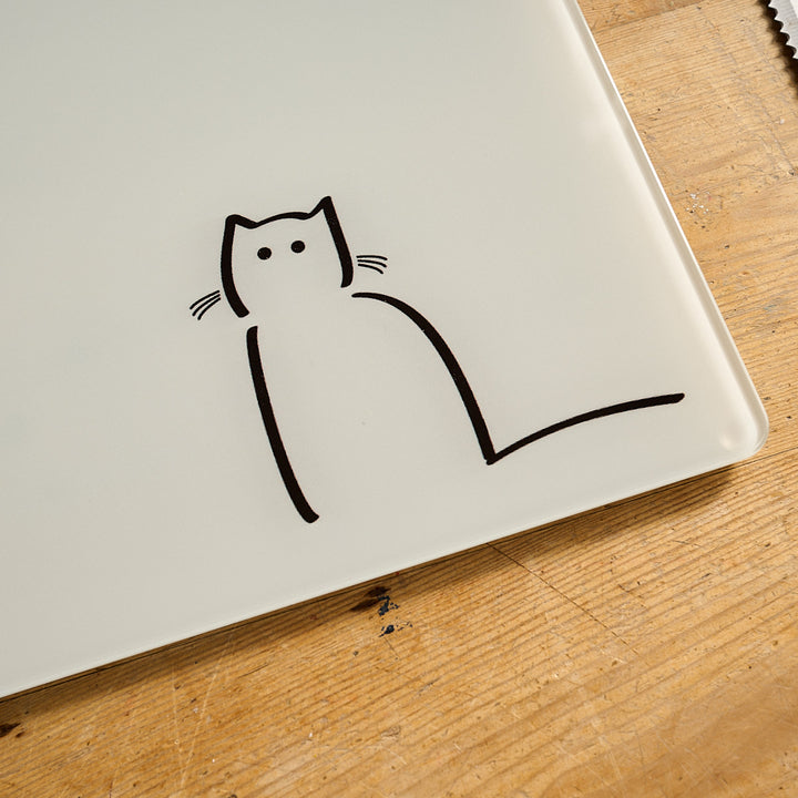 Loafing Cat Glass Worktop Saver close up on a wooden surface.