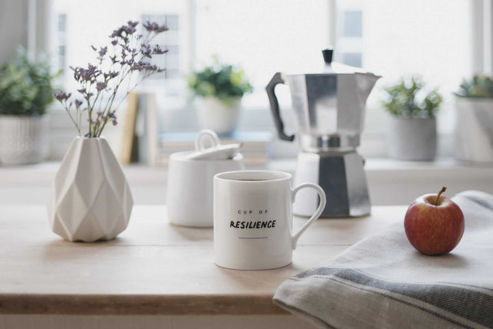 Cup of Resilience Mug on Table with apple